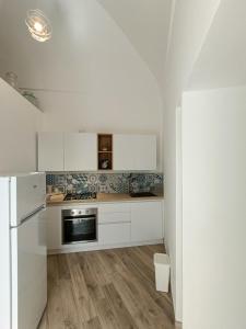 波西塔诺Regina Margherita的厨房配有白色橱柜和冰箱。