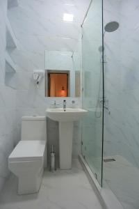 布哈拉Best Hotel Muqaddam的白色的浴室设有水槽和淋浴。