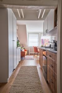 布达佩斯温馨友好II号公寓的厨房配有白色橱柜和厨房地毯。