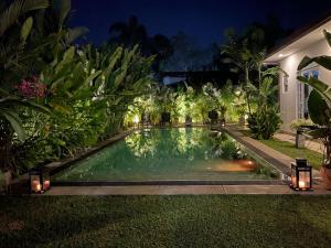 MahabageRoshe-Sky Guest House Colombo的夜间在房子的院子中的一个游泳池
