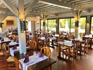 卢瓦尔河畔普伊普宜瑞莱之家酒店的餐厅配有桌椅和紫色餐巾