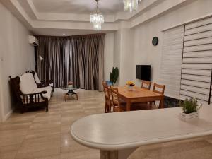 古晋Cozzzy hut Riverbank Suites Kuching with spectacular River view的一间带桌子的客厅和一间餐厅