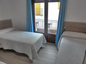 特雷韦莱斯Hostal Casa Fermina- A 2 horas de las pistas de esquí的一间卧室设有两张床,窗户设有阳台