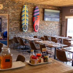 圣维尔巴斯生态汽车旅馆的墙上设有桌子和冲浪板的餐厅