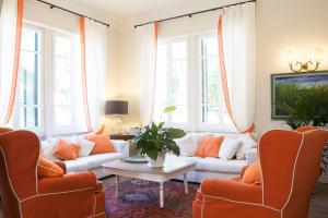 马里纳迪马萨Villa Liberty al mare的客厅配有橙色椅子和白色沙发