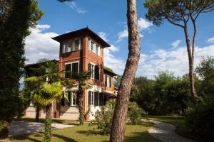 马里纳迪马萨Villa Liberty al mare的前面有一棵树的大砖房子