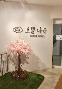 群山市Gunsan Hotel Naun的墙上有粉红色花朵的树