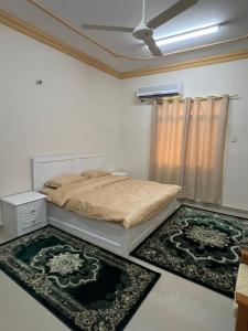 苏尔Orchid sur guest house的一间卧室配有一张床和两块地毯
