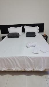 尼泰罗伊Residencial do Centro的一张带两个枕头的白色床