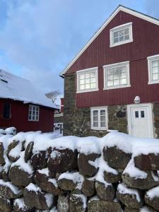 OyndarfjørðurSeaside Cottage的雪屋前的石墙