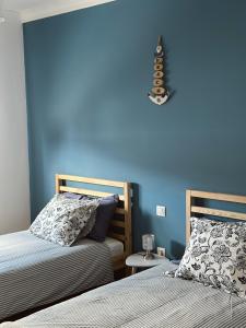 Casillas de MoralesBogalusa的一间卧室设有两张床和蓝色的墙壁
