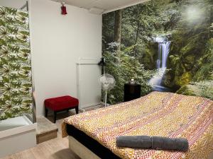 奥克兰Sky World Cozy Home的卧室配有一张壁挂瀑布壁画的床。