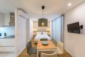 布拉加Braga Center Apartments - Rua do Anjo的配有床和桌子的房间以及厨房