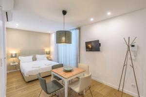 布拉加Braga Center Apartments - Rua do Anjo的卧室配有一张床和一张桌子及椅子