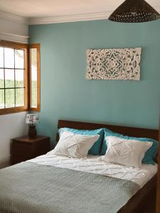 Casillas de MoralesBogalusa的卧室内的一张床铺,卧室内有蓝色的墙壁