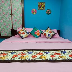 蓬蒂切里Blue Waves HomeStay的一间卧室配有一张带粉色床单和枕头的床。