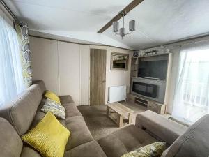 亨斯坦顿Lovely Caravan With Decking At Manor Park In Hunstanton Ref 23091t的带沙发和平面电视的客厅