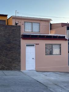 安托法加斯塔Casa Central, Amplia y Cómoda的粉红色的建筑,有白色的门和砖墙