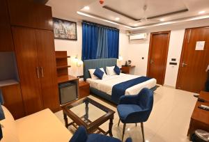新德里Hotel Down Town Paschim Vihar的一间酒店客房,配有一张床和一台电视