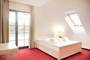 拉多姆斯科Malutkie Resort的白色的卧室设有床和窗户