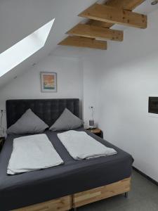 布吕尔Balthasar Neumann Speiserei & Gästehaus - Zentrum Brühl -的一间卧室配有一张带两个枕头的黑色床。