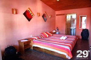 蒙泰韦尔德哥斯达黎加Manakin Lodge, Monteverde的卧室配有一张粉红色墙壁内的大床