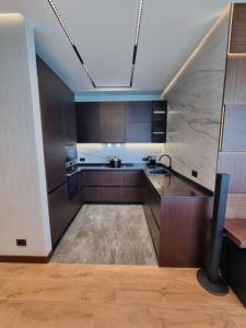 巴统Premium apartment in Porta Batumi Tower的厨房配有棕色橱柜和水槽