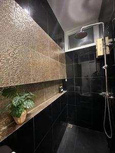 Ban Bang PhangThe Lake Guest House的带淋浴和植物的黑色浴室
