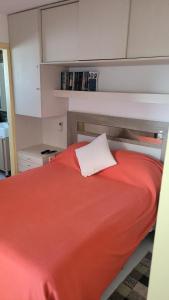 埃斯特角城APARTAMENTO 1 DORMITORIO EN PUNTA DEL ESTE的卧室配有红色的床和白色枕头