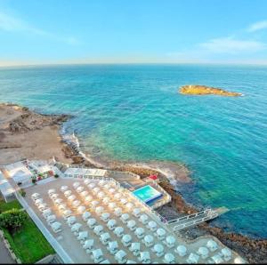 托雷圣乔万尼乌Appartamenti Vista Mare Salento的享有海滩的空中景致,配有遮阳伞和海洋
