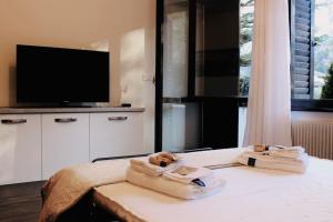 卡尔切拉尼卡阿拉戈[Fronte lago]ResidenceGarden, moderno appartamento的一间卧室配有一张床,上面有两条毛巾