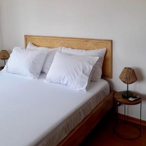 AroeiraNini's Beach House - Aroeira, Charneca da Caparica的一张带白色床单和枕头的床
