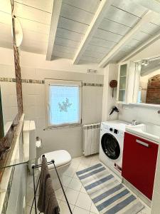 LuniAppartamento Cà Insulae的一间带洗衣机和水槽的浴室