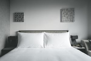 札幌SAPPORO STREAM HOTEL的卧室配有一张白色床,墙上挂有两张照片