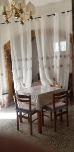 阿尔贝罗贝洛Trullo Chiancola Antica的一间卧室配有床和两把椅子及窗帘