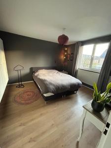 奈梅亨Compleet huis in Nijmegen的一间卧室设有一张床和一个大窗户