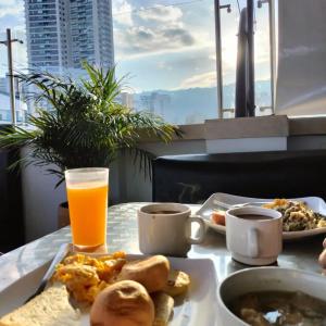 布卡拉曼加阿莱西奥酒店的一张桌子,上面放着一盘食物和一杯橙汁