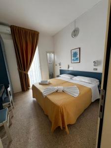 里米尼提奥酒店 的酒店客房,配有一张带弓的床铺