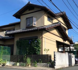 熊本KOTO TEA HOUSE - Vacation STAY 12837的前面有栅栏的黄色房子