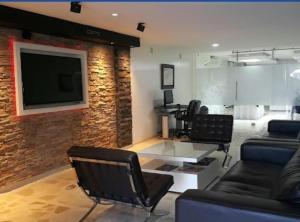 布卡拉曼加阿莱西奥酒店的客厅配有椅子和砖墙上的电视