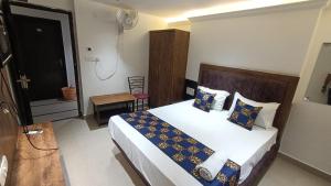 戈勒克布尔HOTEL SAI PALACE的一间卧室配有蓝色和黄色枕头的床
