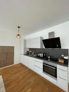 科隆Queens Peak Apartment的厨房配有白色橱柜和炉灶烤箱。