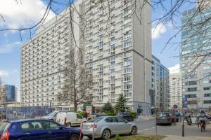 华沙Pereca Stylish Apartment Warsaw & Air Conditioning by Rent like home的一座大型建筑,有汽车停在城市里