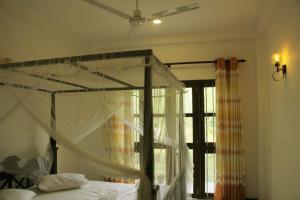 高尔Lion House的一间卧室设有天蓬床和窗户。