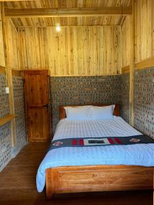 萨帕Chacha's House的木制客房内的一间卧室,配有一张床