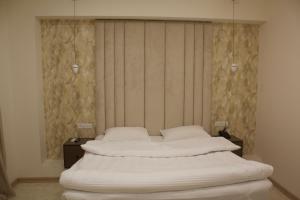 ArbatʼLux Plaza Hotel的一张床位,房间设有两个床头柜和四柱床