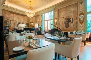 罗马罗马皇宫大酒店的一间带桌椅和吊灯的用餐室