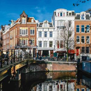 阿姆斯特丹阿姆斯特丹维赫曼酒店的一座建有建筑物的城市里河流上的桥梁