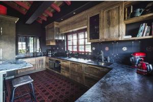 谷雪维尔Chalet sisimut的铺有红色地板并配有木制橱柜的厨房