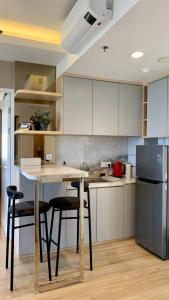 秾莎Two Bedroom Apartment at The Nove, Nuvasa Bay, Nongsa 719的厨房配有桌椅和冰箱。